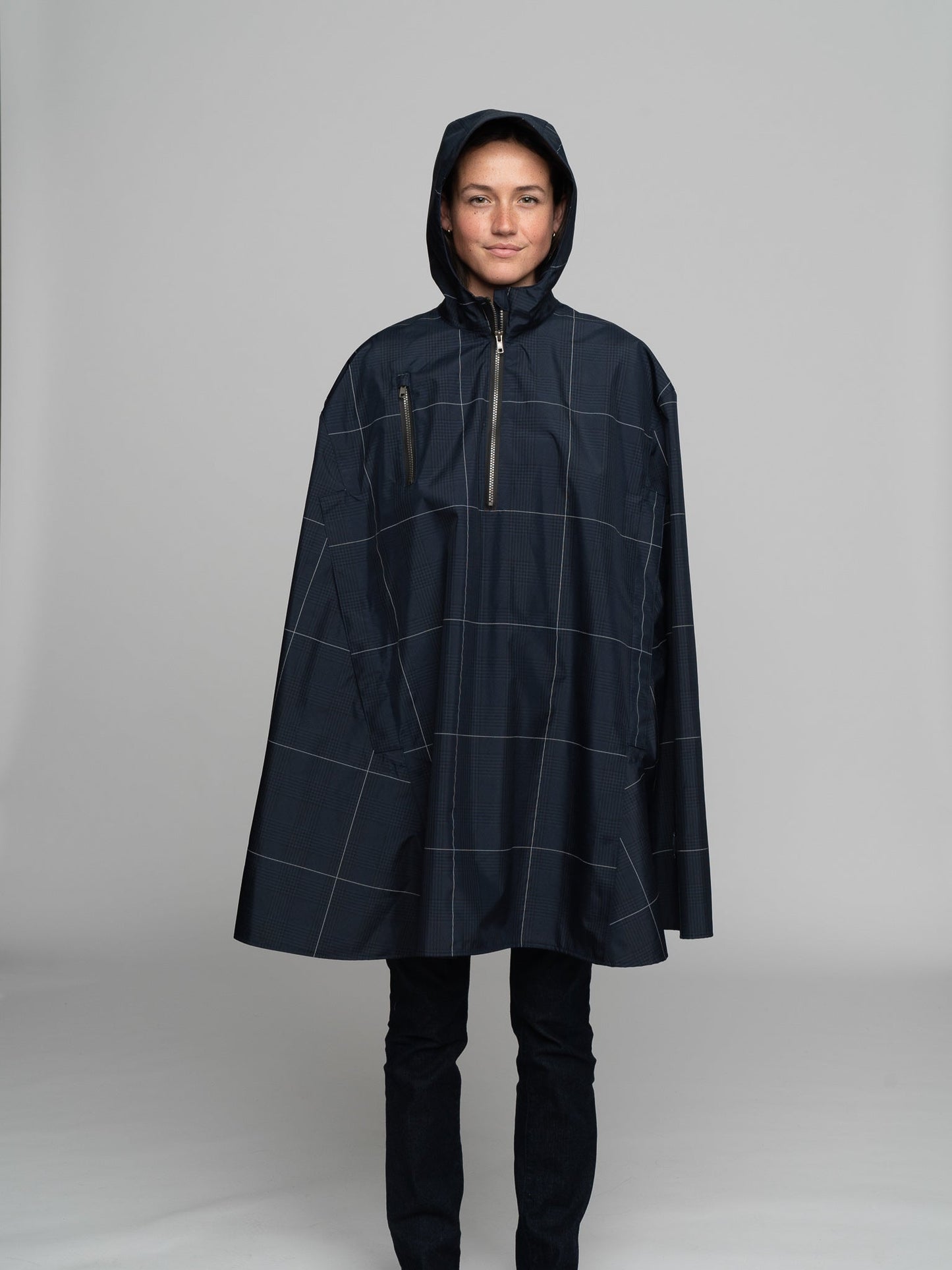 Great for walking or riding travels and commutes. Made of sustainable, recycled polyester. Navy and white check with interwoven reflective thread creates a bright hi-vis grid that stands out on rainy days and nights. Elastic thumb loops keep the poncho secure when riding. Fully seam-sealed, and carefully crafted.